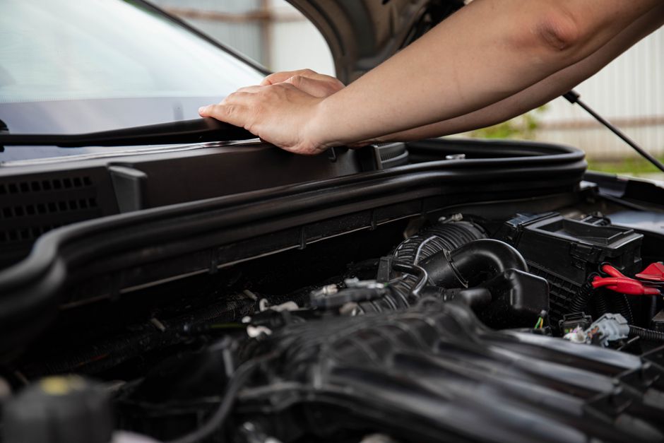 Meccanico che controlla il motore di un'auto in officina