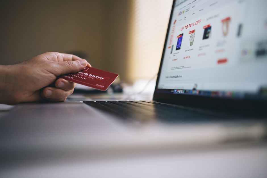 Acquisti online con carrello, carta di credito e smartphone su una scrivania