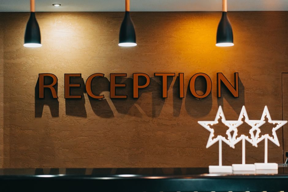 Reception e hall di un hotel a Napoli con personale all'accoglienza
